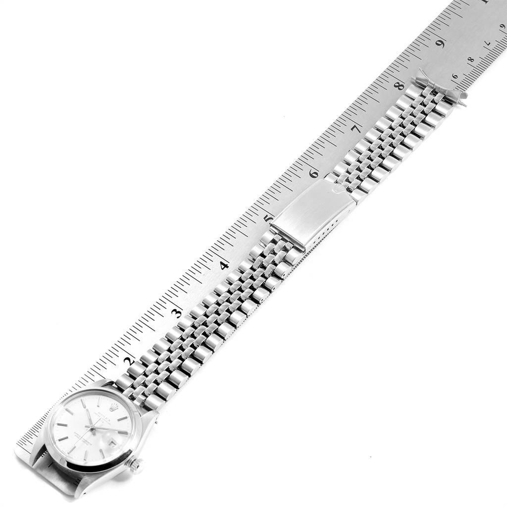 The Vintage Collection Rolex watch is shown from a top-down angle, displaying its face, bracelet, and clasp next to a ruler for scale.