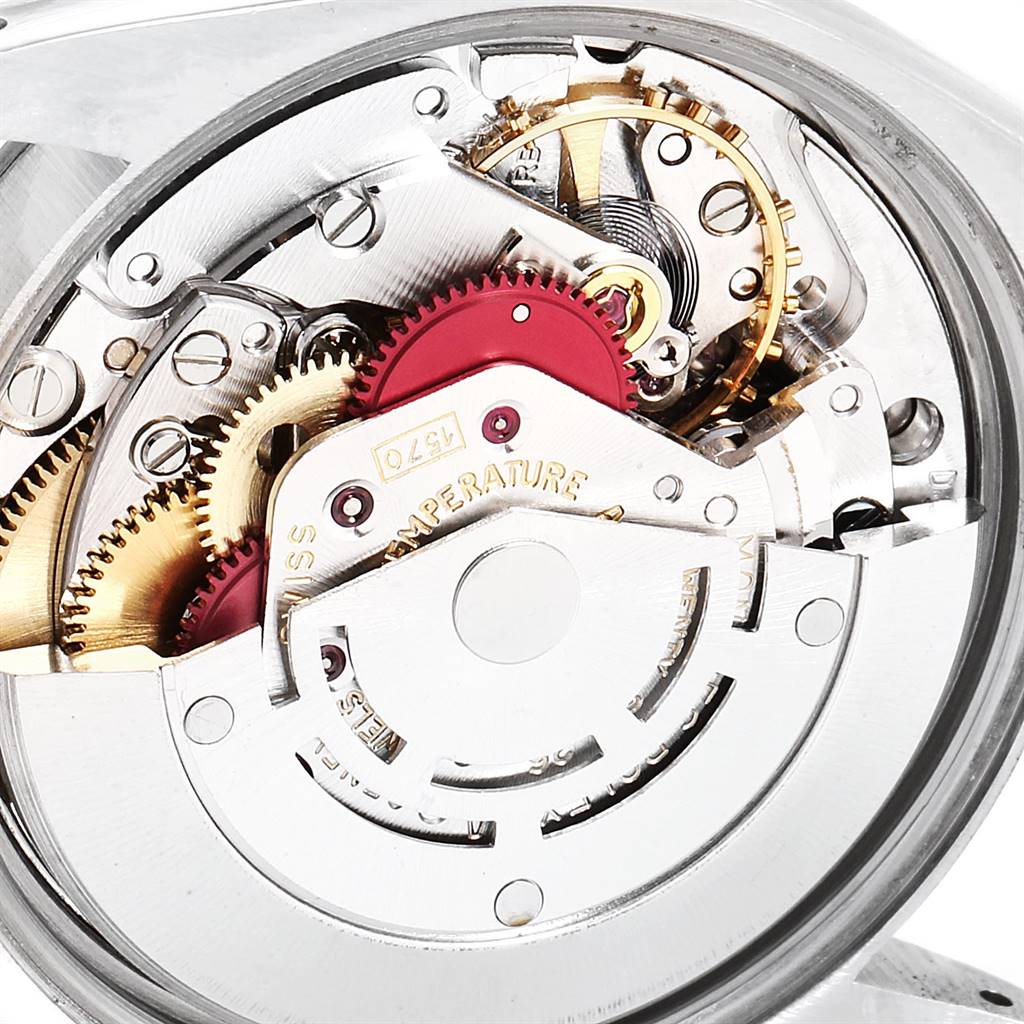 The image shows a close-up of the inner mechanical components of the Rolex Vintage Collection 15000 Men
s Stainless Steel Silver Dial 15000 Men
s Stainless Steel Silver Dial watch, revealing gears and intricate parts.
