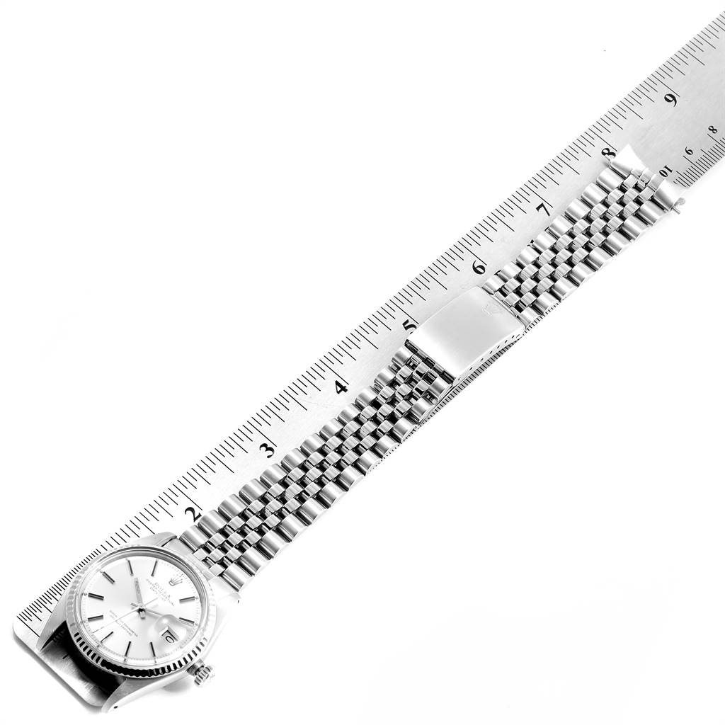 This image shows a Vintage Collection Rolex watch laid against a ruler, depicting its face, bezel, crown, and metal bracelet.