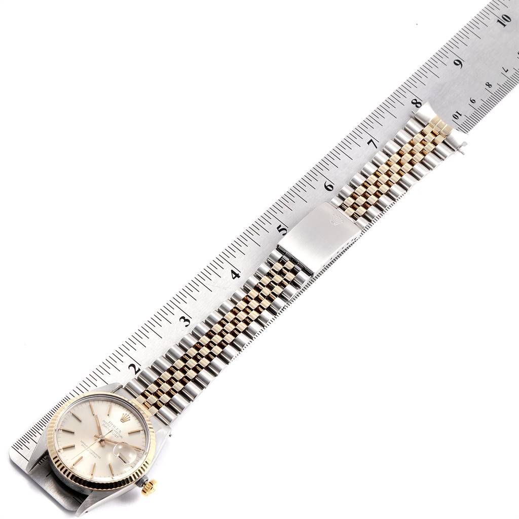 This angled shot of the Rolex Vintage Collection 16013 Men
s Stainless Steel Silver Dial 16013 Men
s Stainless Steel Silver Dial model shows the full watch face and two-tone bracelet alongside a measuring ruler.