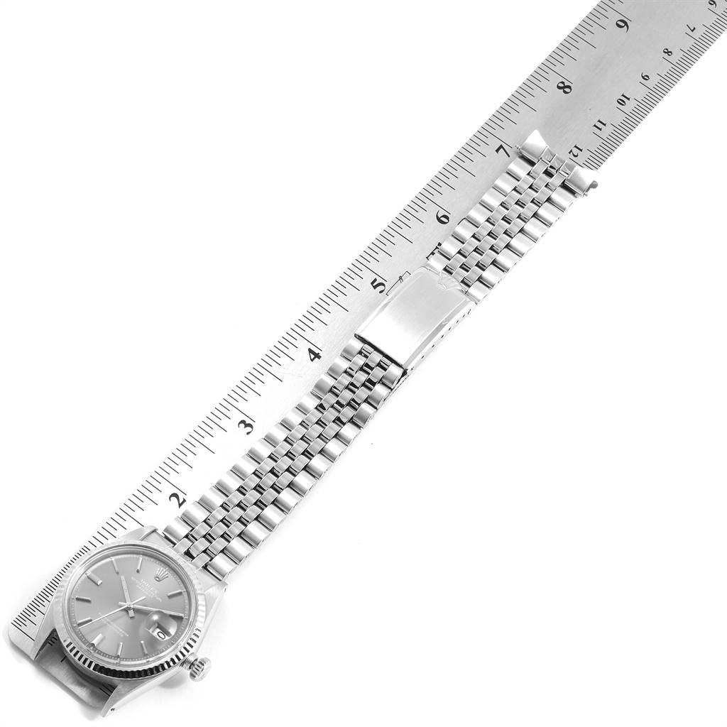 The image shows a top view of a Rolex Vintage Collection 1601 Men's Stainless Steel Grey Dial 1601 Men's Stainless Steel Grey Dial watch with the face, bracelet, and clasp aligned with a ruler.