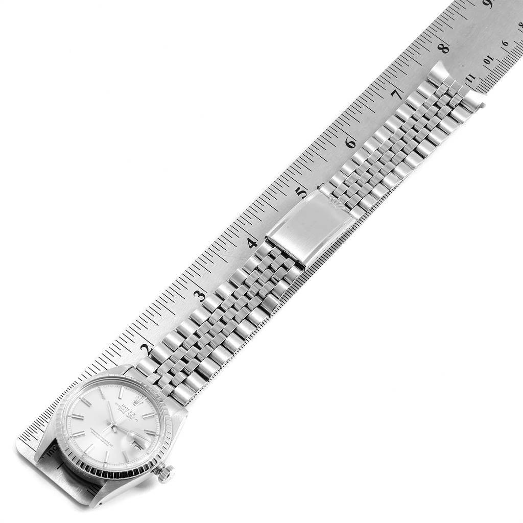 This image shows a Rolex Vintage Collection 1601 Men
s Stainless Steel Silver Dial 1601 Men
s Stainless Steel Silver Dial watch laid out flat with a ruler for measurement, displaying the face, bezel, and metal bracelet.