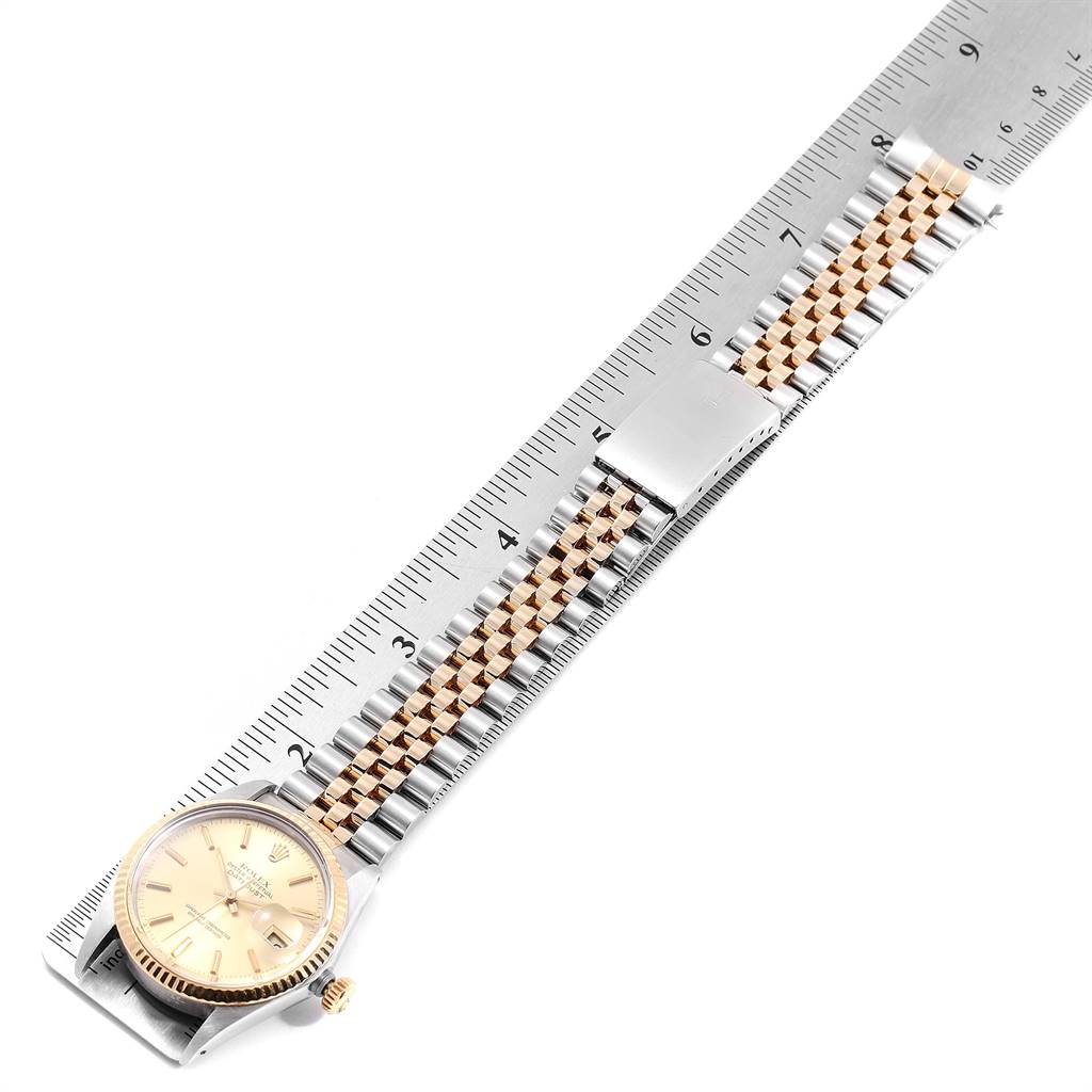 The image shows the Rolex Vintage Collection 16013 Men's Stainless Steel Champagne Dial 16013 Men's Stainless Steel Champagne Dial model watch at an angle, highlighting its face, bezel, and band against a ruler.