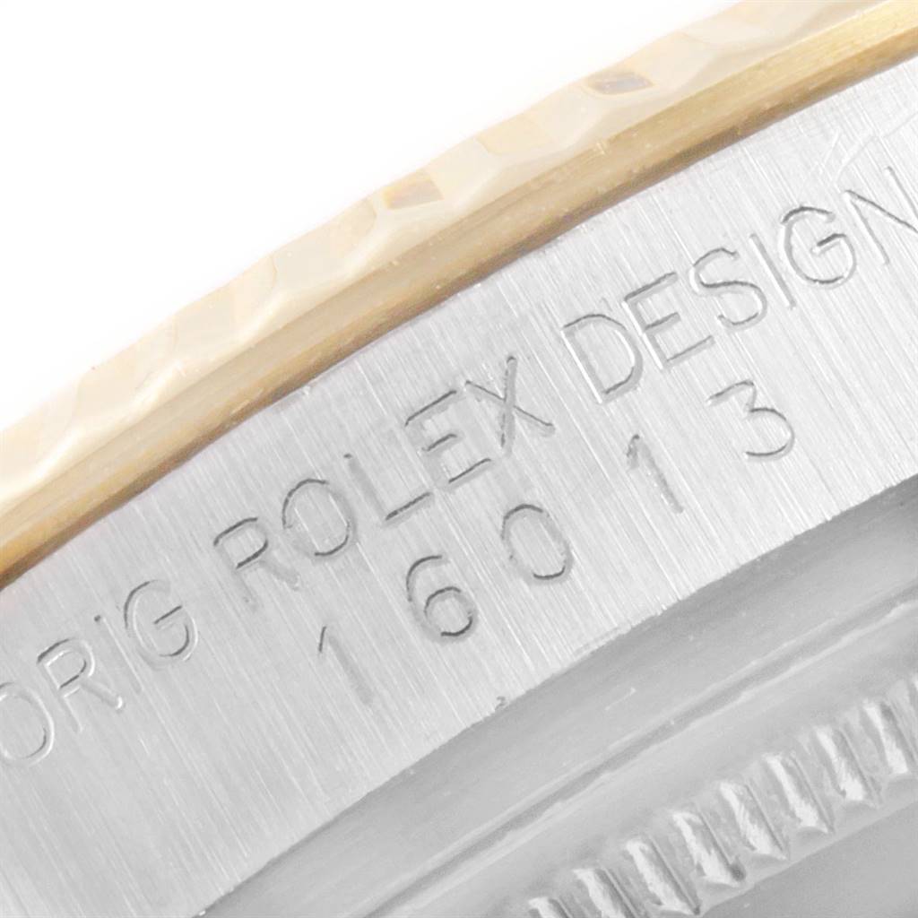 Close-up of the edge and engraving on a Vintage Collection Rolex watch, showing part of the bezel and case.