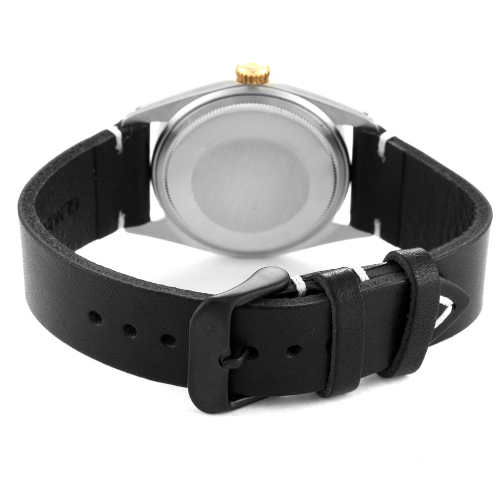 The image shows the back view of a Rolex Vintage Collection 1601 Men
s Steel and Gold (two tone) Champagne Dial 1601 Men
s Steel and Gold (two tone) Champagne Dial watch, highlighting the case back and black leather strap with buckle.