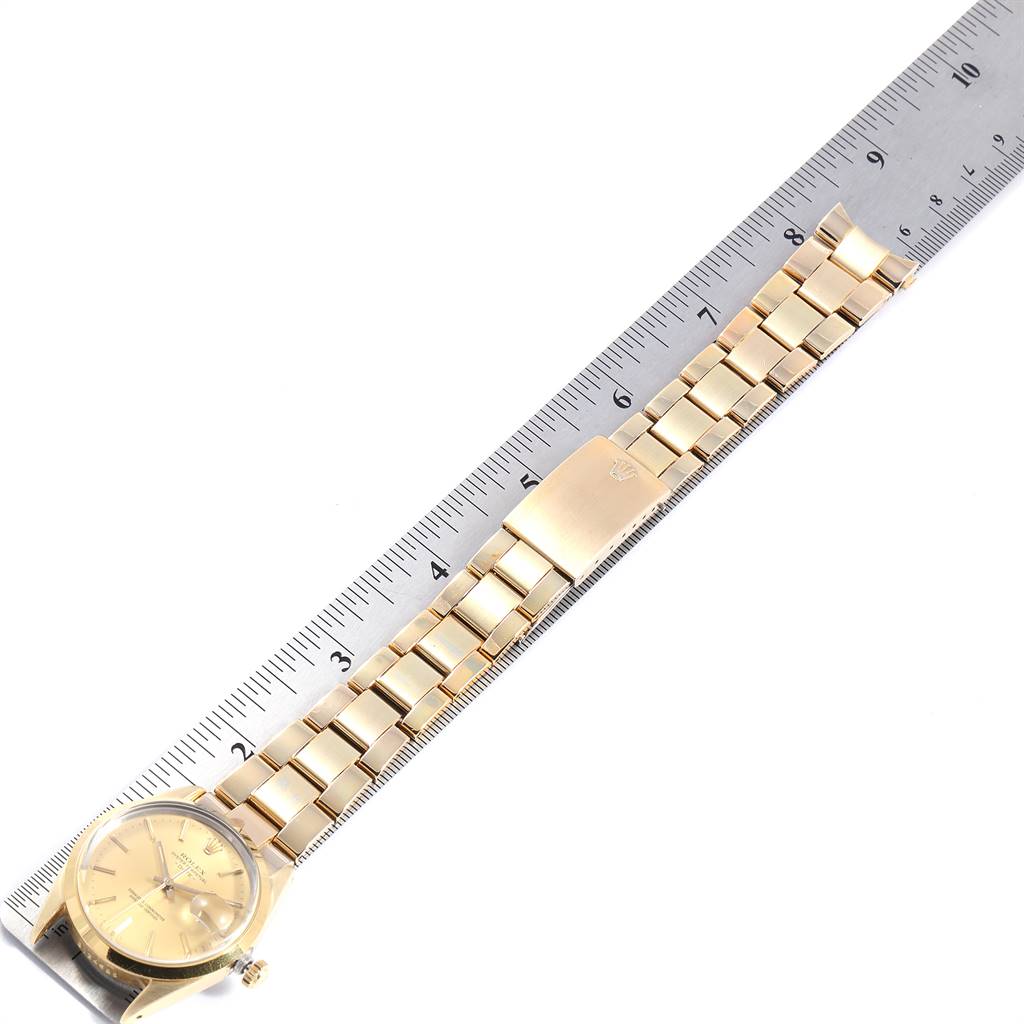 The image shows a top view of a Rolex Vintage Collection 15505 Men
s Champagne Dial 15505 Men
s Champagne Dial watch with a focus on its golden strap and metallic ruler for scale.