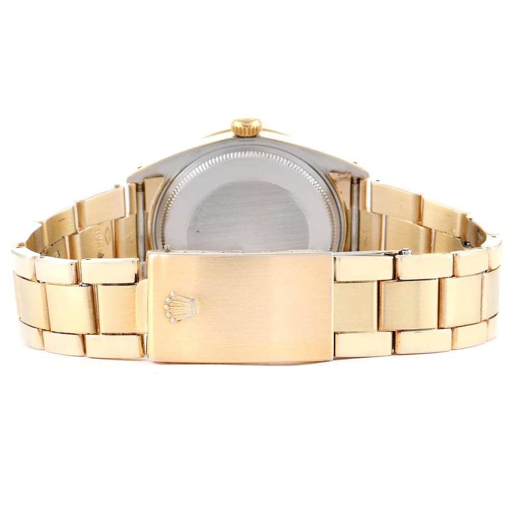 The image shows the back view of a Rolex Vintage Collection 15505 Men
s Champagne Dial 15505 Men
s Champagne Dial watch, highlighting its gold bracelet and clasp.