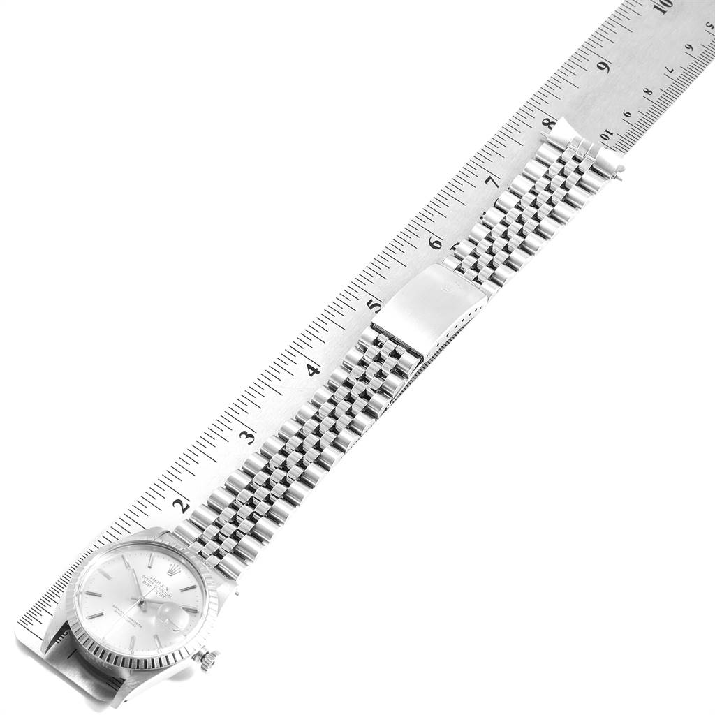 The image shows a top-down view of a Rolex Vintage Collection 16030 Men
s Stainless Steel Silver Dial 16030 Men
s Stainless Steel Silver Dial model watch, displaying its face, bracelet, and a measuring ruler.