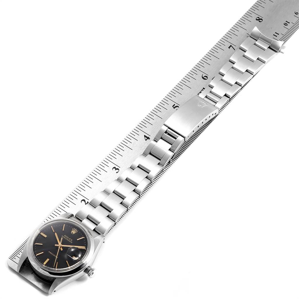 The image displays a Rolex Vintage Collection 6694 Men's Stainless Steel Black Dial 6694 Men's Stainless Steel Black Dial watch laid flat with its metal strap measured against a ruler.