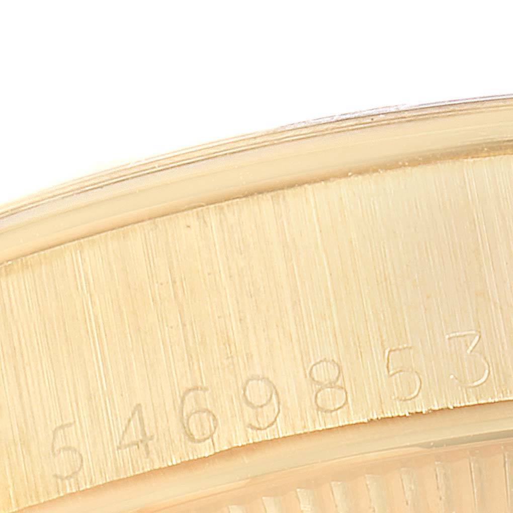 This close-up image shows the gold bezel of a Vintage Collection model by Rolex, featuring engraved serial numbers.