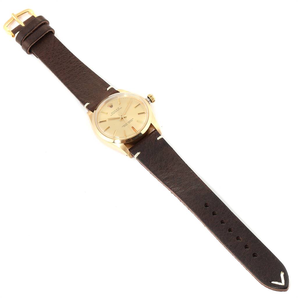 The Vintage Collection Rolex watch is shown from a top-down angle, displaying its dial, case, crown, and leather strap.