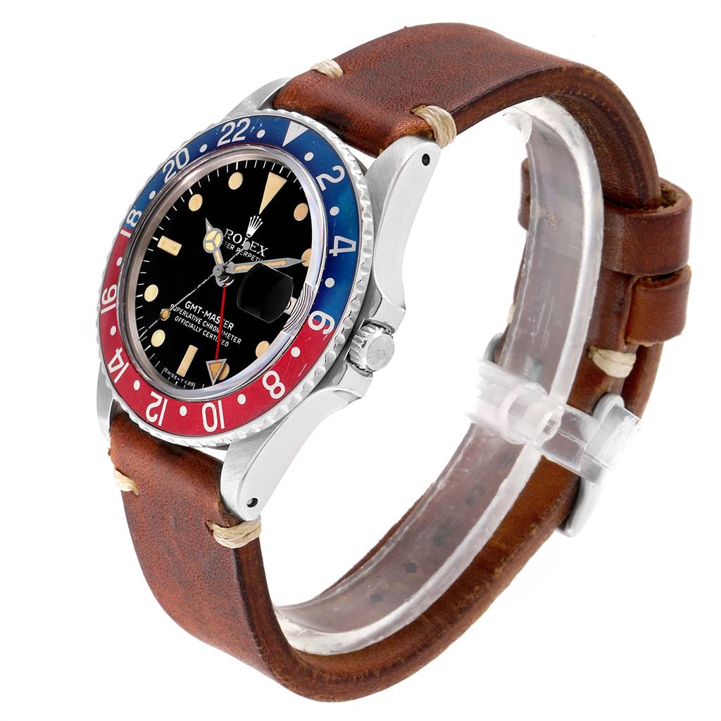 The image shows an angled view of a Rolex Vintage Collection 1675 Men
s Stainless Steel Black Dial 1675 Men
s Stainless Steel Black Dial GMT-Master watch with a leather strap and a red-blue bezel.