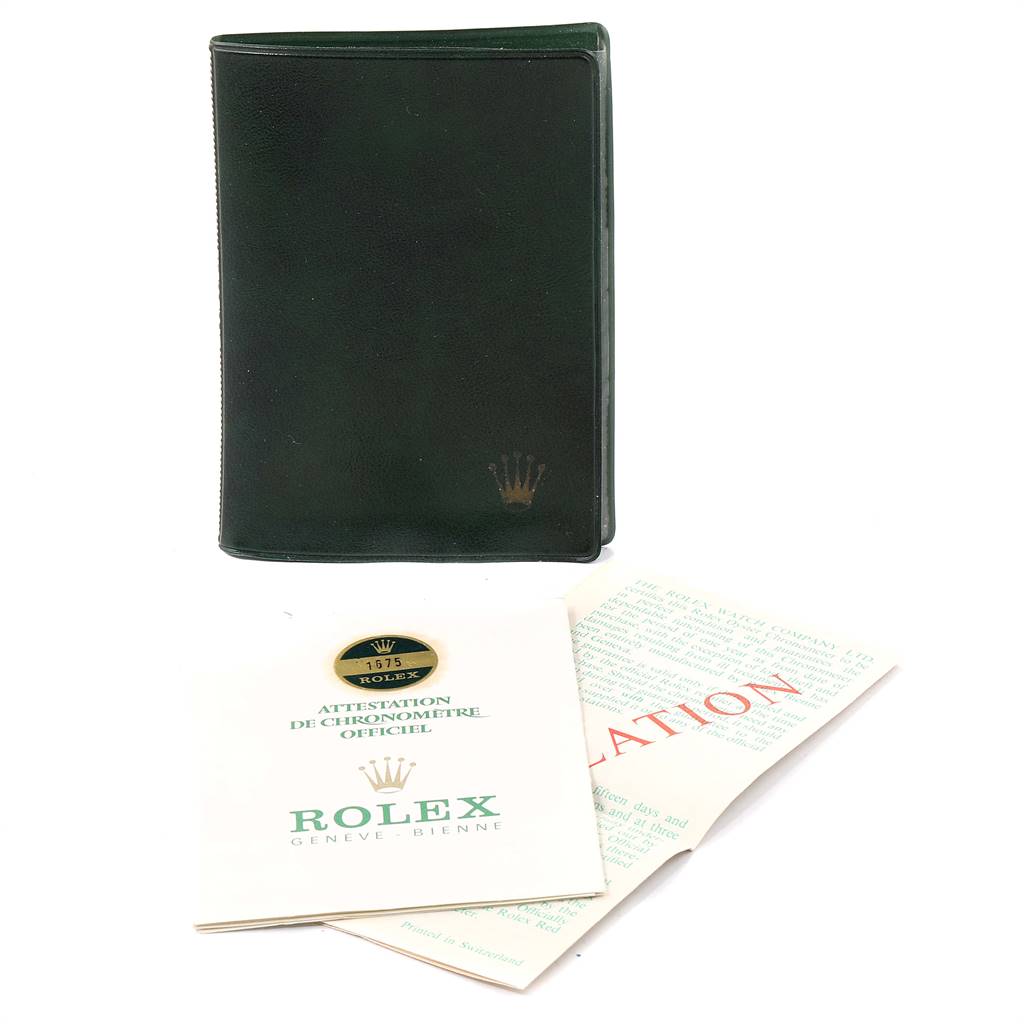 The image shows a leather Rolex Vintage Collection 1675 Men
s Stainless Steel Black Dial 1675 Men
s Stainless Steel Black Dial holder, a certificate, and accompanying documents from a top-down angle.