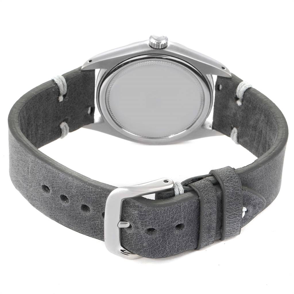 The image shows the back view of a Rolex Vintage Collection 6694 Men
s Stainless Steel Silver Dial 6694 Men
s Stainless Steel Silver Dial watch, highlighting its case, crown, and leather strap with buckle.