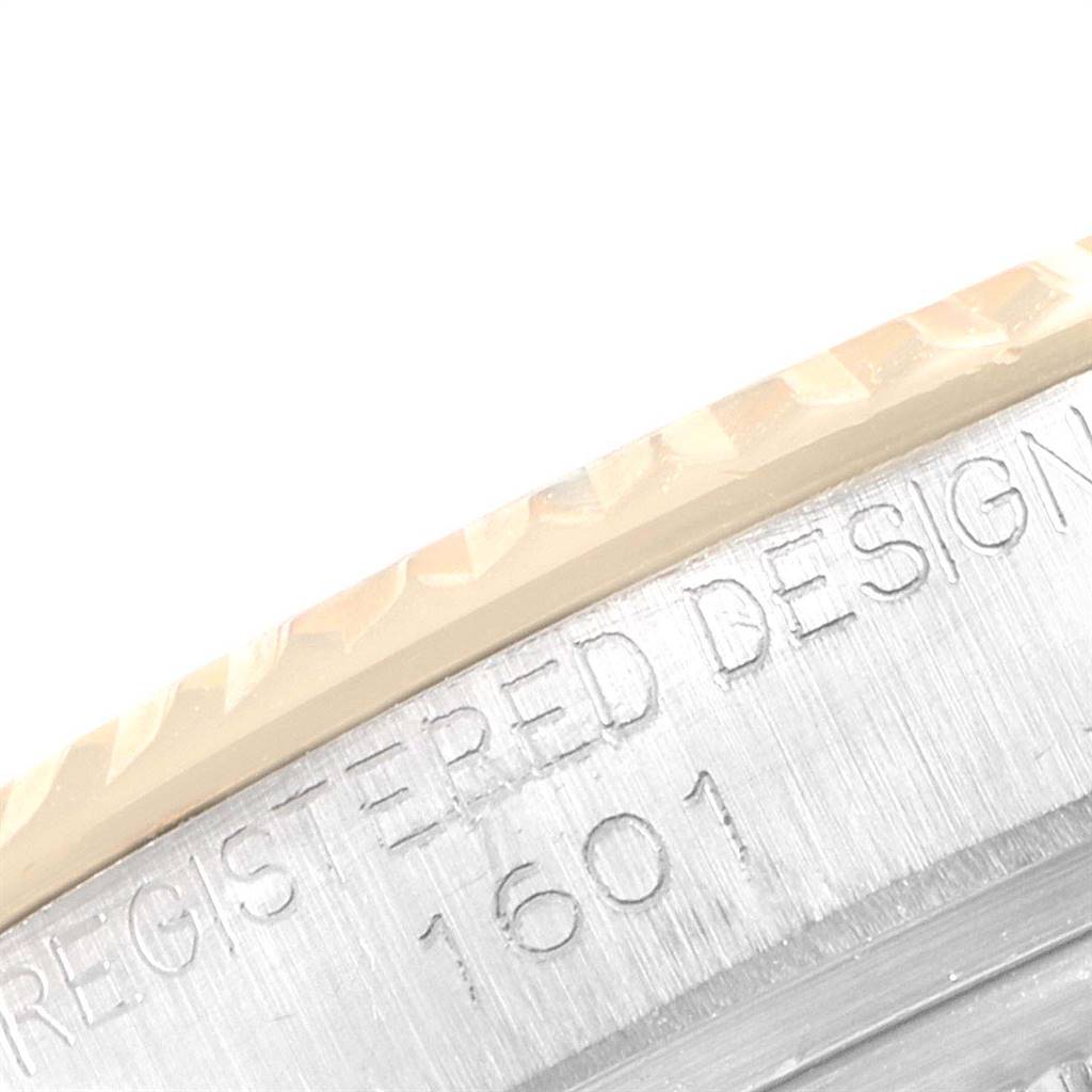 The image shows an extreme close-up of the Rolex Vintage Collection 1601 Men
s Stainless Steel Silver Dial 1601 Men
s Stainless Steel Silver Dial model
s case, with visible engraving and part of the bezel.