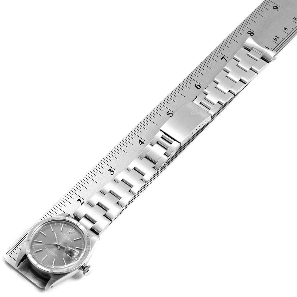 The Rolex Vintage Collection 1501 Men's Stainless Steel Grey Dial 1501 Men's Stainless Steel Grey Dial watch is shown from a top view with a metal bracelet alongside a ruler for measurement.