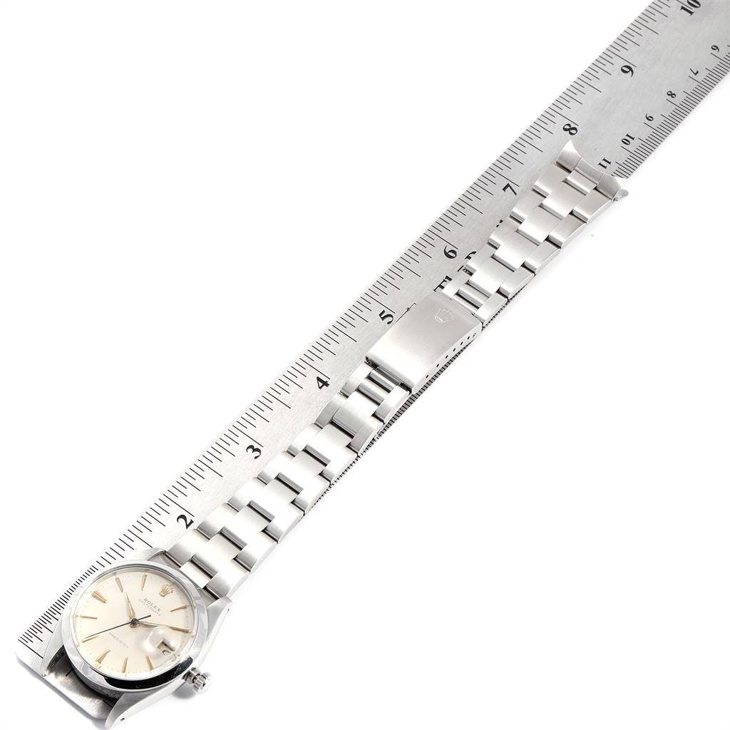 Aerial view of a Rolex Vintage Collection 6694 Men
s Stainless Steel Silver Dial 6694 Men
s Stainless Steel Silver Dial watch displaying the face, bracelet, and clasp next to a ruler for measurement.