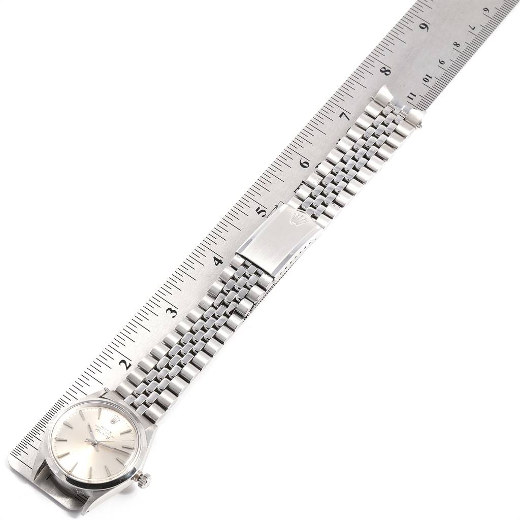 The image shows a Rolex Vintage Collection 5500 Men
s Stainless Steel Silver Dial 5500 Men
s Stainless Steel Silver Dial watch laid flat on a ruler, showcasing the face, bracelet, and clasp.