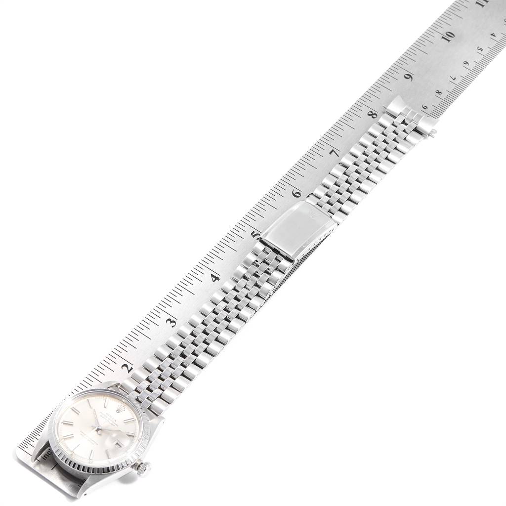 The Rolex Vintage Collection 1601 Men
s Stainless Steel Silver Dial 1601 Men
s Stainless Steel Silver Dial watch is shown from a top-down angle, highlighting the face and metal bracelet alongside a ruler.