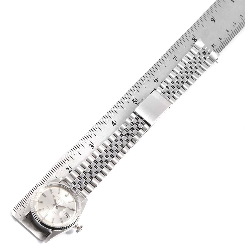 The image shows a top-down view of a Rolex Vintage Collection 1601 Men's Stainless Steel Silver Dial 1601 Men's Stainless Steel Silver Dial watch, focusing on the face and metal bracelet laid next to a ruler.