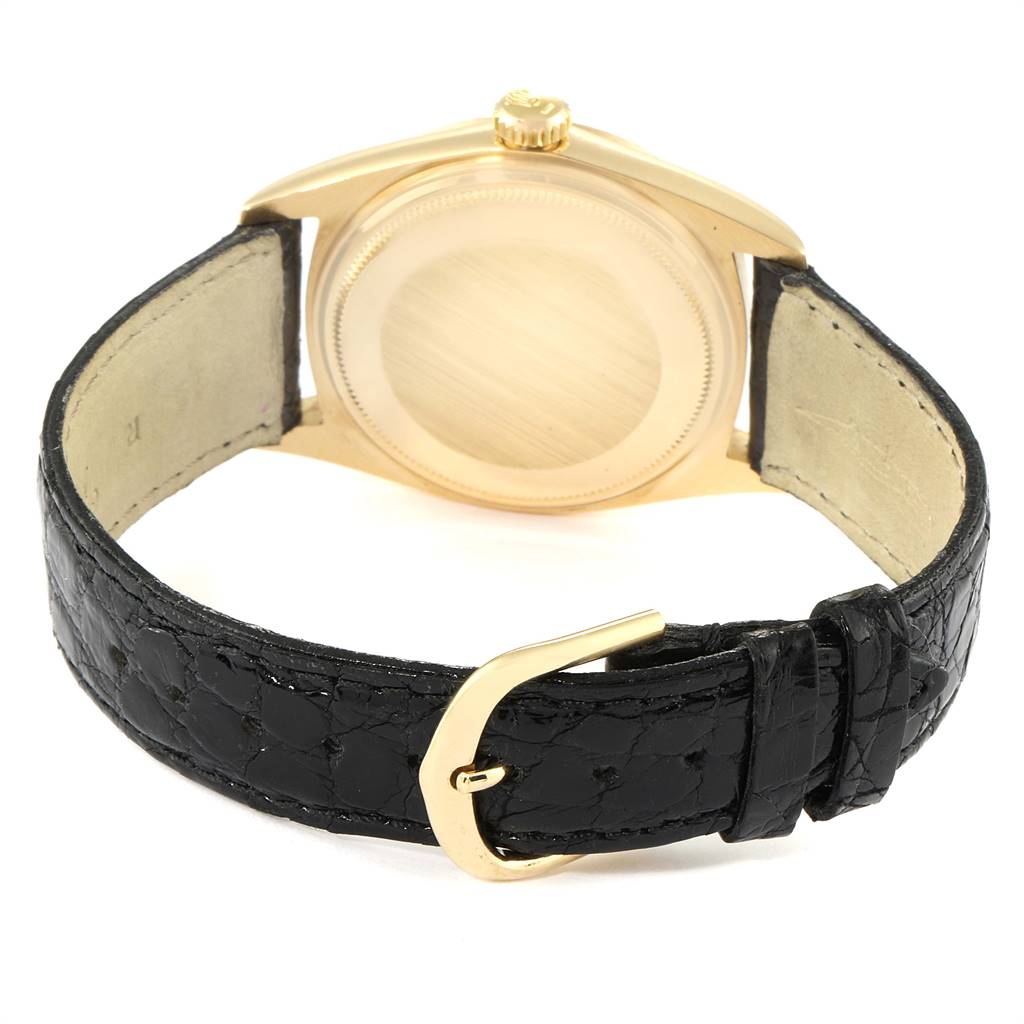 The image shows the back view of a Rolex Vintage Collection 1803 Men's Yellow Gold Champagne Dial 1803 Men's Yellow Gold Champagne Dial model watch featuring its caseback and leather strap with buckle.