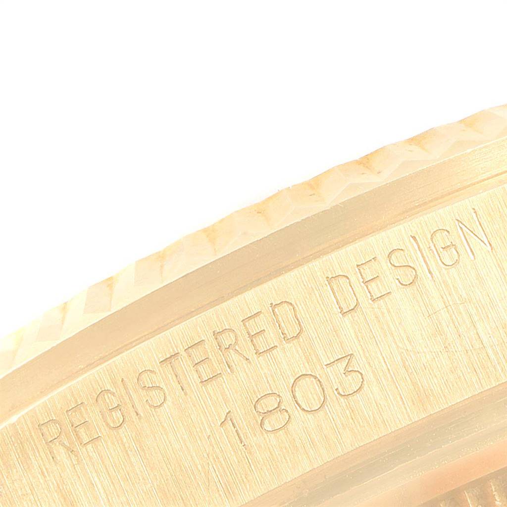 This close-up image shows the engraved "REGISTERED DESIGN 1803" on the side of the bezel of a Rolex Vintage Collection 1803 Men's Yellow Gold Champagne Dial 1803 Men's Yellow Gold Champagne Dial watch.