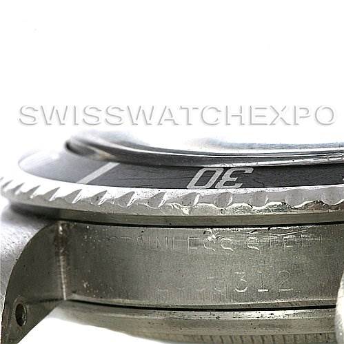 This image shows a close-up side view of the bezel and case of a Vintage Collection Rolex watch, revealing its stainless steel material.