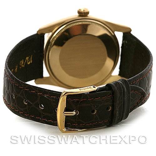 This image shows the back view of a Rolex Vintage Collection 1011 Men's Yellow Gold Champagne Dial 1011 Men's Yellow Gold Champagne Dial watch, highlighting the case back and leather strap with a buckle.