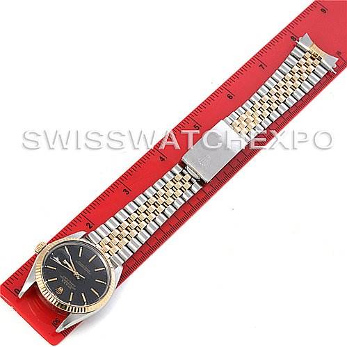 The image shows a top view of the Rolex Vintage Collection 16013 Men
s Stainless Steel Black Dial 16013 Men
s Stainless Steel Black Dial watch laid flat alongside a red ruler for scale.