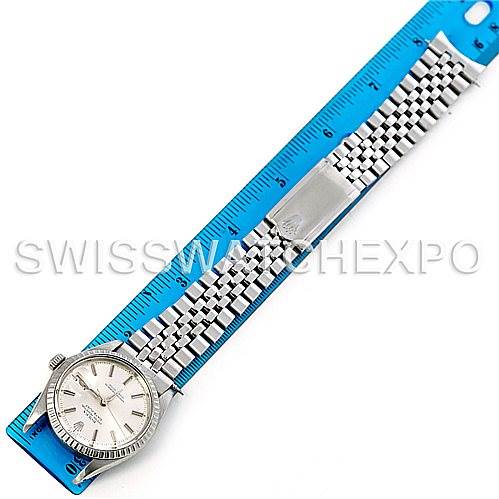 The image shows a top-down view of a Rolex Vintage Collection 1601 Men's Stainless Steel Silver Dial 1601 Men's Stainless Steel Silver Dial watch with a metal bracelet placed next to a blue ruler for size reference.