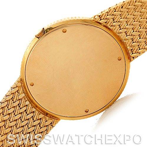 The image shows the back and part of the woven strap of a Rolex Vintage Collection 9577 Men's Yellow Gold Champagne Dial 9577 Men's Yellow Gold Champagne Dial watch.