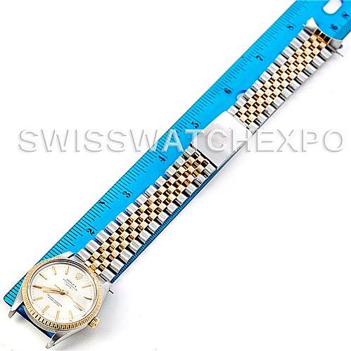 This image shows a top-down view of a Rolex Vintage Collection 15053 Men's Stainless Steel Silver Dial 15053 Men's Stainless Steel Silver Dial watch with a gold and silver bracelet, next to a measuring ruler.