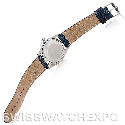 The image shows the back view of a Vintage Collection Rolex watch with a tan leather strap and blue accents.