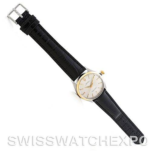 The image shows a top-down view of a Rolex Vintage Collection 1002 Men's Steel and Gold (two tone) Silver Dial 1002 Men's Steel and Gold (two tone) Silver Dial model watch, featuring a black leather strap and a white dial.