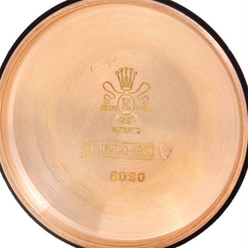 This image shows the interior of the back cover of a Rolex Vintage Collection 6090 Men's Rose Gold Silver Dial 6090 Men's Rose Gold Silver Dial model, featuring engravings, hallmark, and model number.