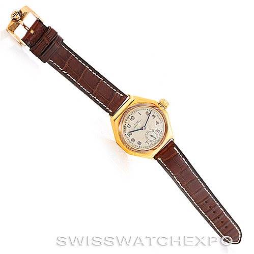 The image shows a top-down view of a Vintage Collection model by Rolex, featuring a brown leather strap and a gold-tone case.