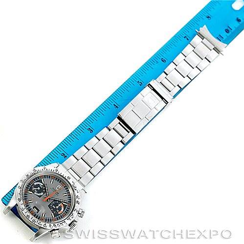 The image shows a flat-lay view of a Rolex Vintage Collection 7159 Men's Stainless Steel Grey Dial 7159 Men's Stainless Steel Grey Dial watch, featuring the full bracelet, dial, and part of a blue ruler.