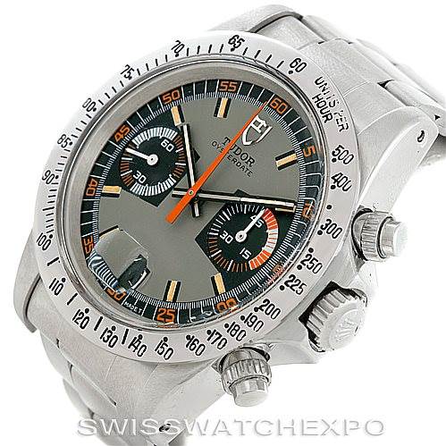 The image shows a vintage Rolex Oyster Cosmograph watch at an angled view, highlighting the face, bezel, crown, and chronograph pushers.