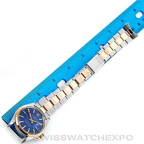 The Rolex Vintage Collection 1500 Men's Steel and Gold (two tone) Blue Dial 1500 Men's Steel and Gold (two tone) Blue Dial watch is shown flat with its full band extended alongside a blue ruler, displaying the face, band, and clasp.