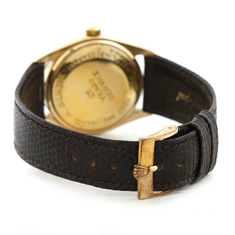 The image shows the back of a Vintage Collection Rolex watch, focusing on its case back and brown leather strap with a buckle.