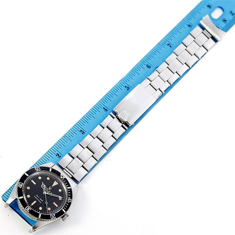 The Vintage Collection Rolex watch is shown from a top-down angle, displayed alongside a blue ruler for scale.