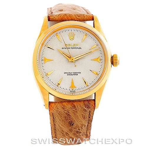 This image shows a front view of a Rolex Vintage Collection 6564 Men's Yellow Gold Silver Dial 6564 Men's Yellow Gold Silver Dial watch with a gold case and brown leather strap.