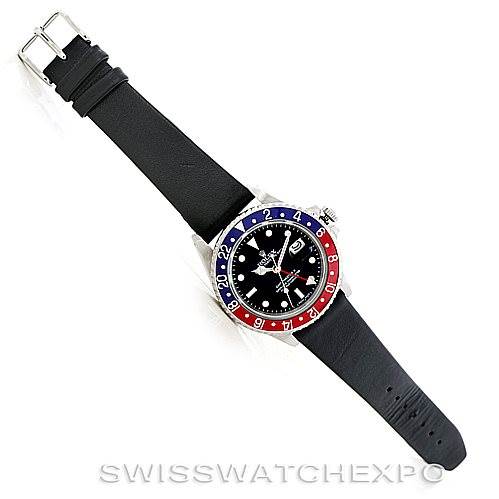The image shows a top-down view of a Vintage Collection Rolex watch with a black strap and a red and blue bezel.