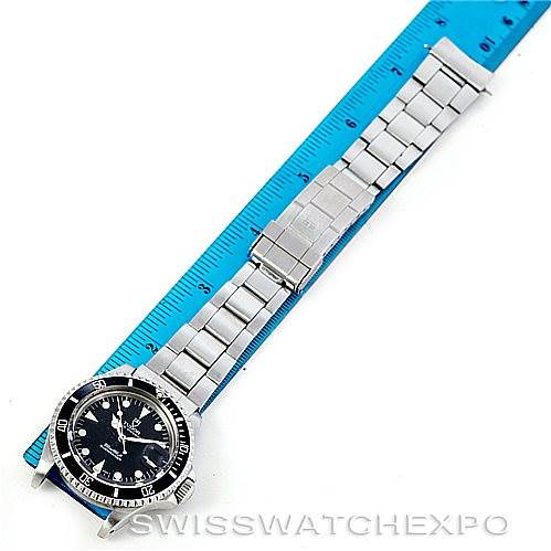 The image shows a Tudor Submariner 79090 Men's Stainless Steel Black Dial 79090 Men's Stainless Steel Black Dial watch laid flat next to a ruler, displaying its face and metal bracelet.