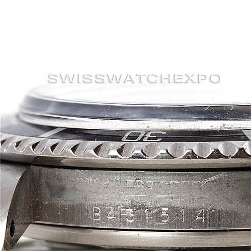 This image shows a side angle of the Tudor Submariner 79090 Men's Stainless Steel Black Dial 79090 Men's Stainless Steel Black Dial watch, focusing on the bezel, crystal, and part of the case with its serial number.