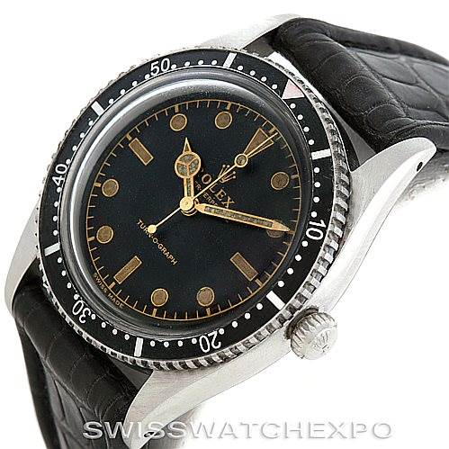 A Vintage Collection model by Rolex is shown at an angle displaying its black dial, bezel, and leather strap.
