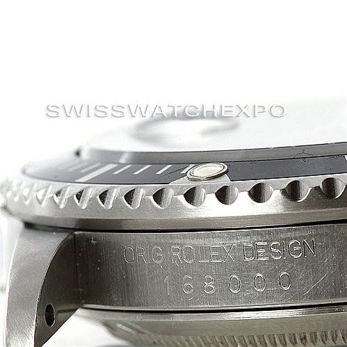 The image shows a side angle of the bezel and case of a Rolex Vintage Collection 168000 Men's Stainless Steel Black Dial 168000 Men's Stainless Steel Black Dial watch, featuring engraving and part of the model number.