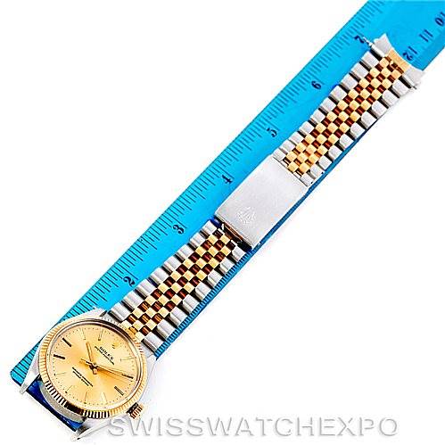 The image shows a top-down view of a Rolex Vintage Collection 1005 Men's Stainless Steel Champagne Dial 1005 Men's Stainless Steel Champagne Dial watch with a gold dial and a two-tone bracelet next to a blue ruler.