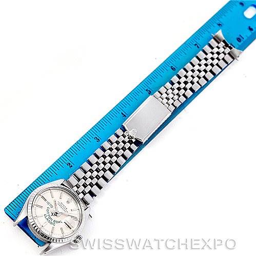 The image shows a Rolex Vintage Collection 1603 Men's Stainless Steel Silver Dial 1603 Men's Stainless Steel Silver Dial watch laid out flat next to a blue ruler, displaying the face, band, and clasp.