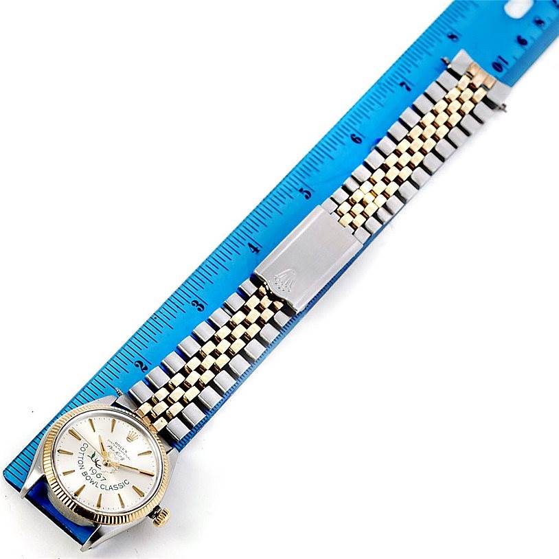 The Rolex Vintage Collection 5501 Men's Steel and Gold (two tone) Silver Dial 5501 Men's Steel and Gold (two tone) Silver Dial watch is shown from a top-down angle, displaying its face, bezel, and metal bracelet alongside a ruler.